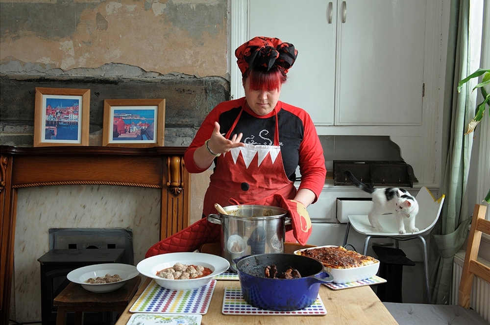 MK food revolution woman cooking holding a pan with oven gloves photo colour